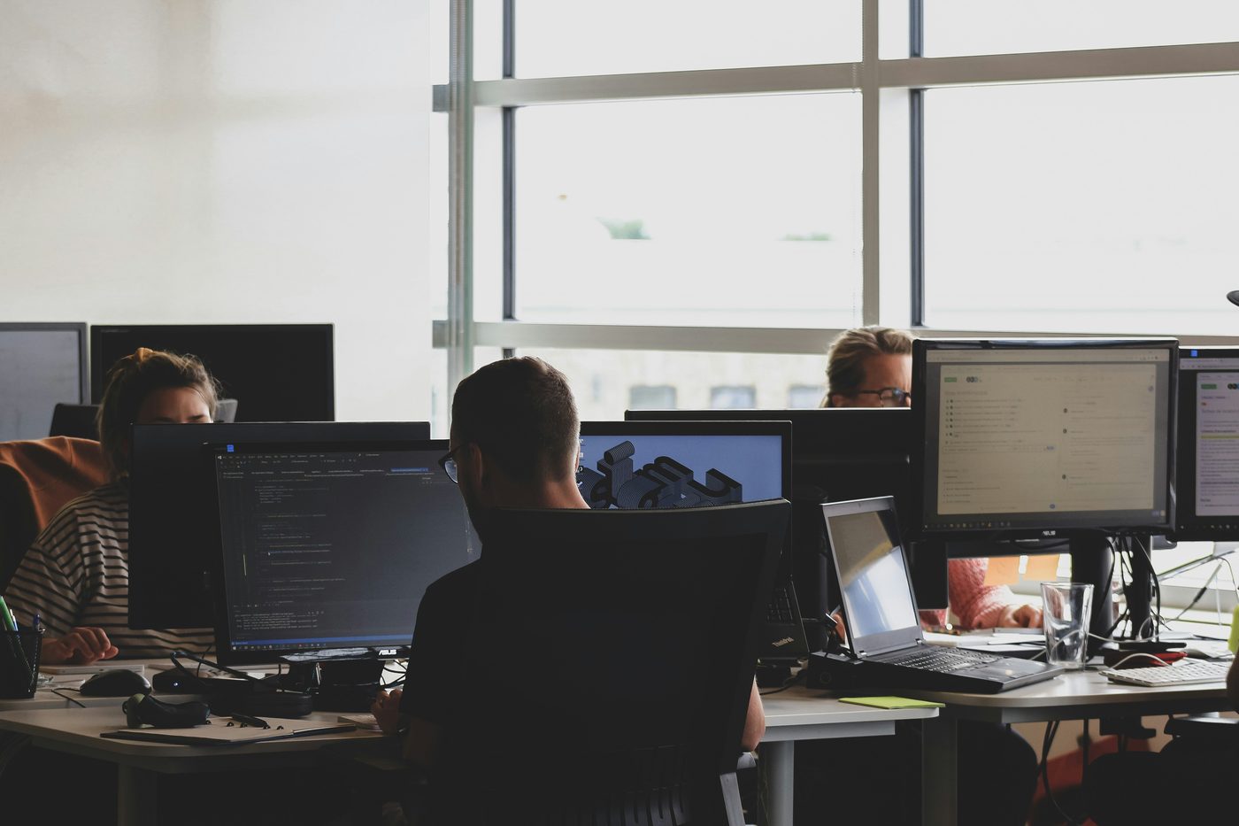 Engineers working at multi-monitor workstations in a shared studio space